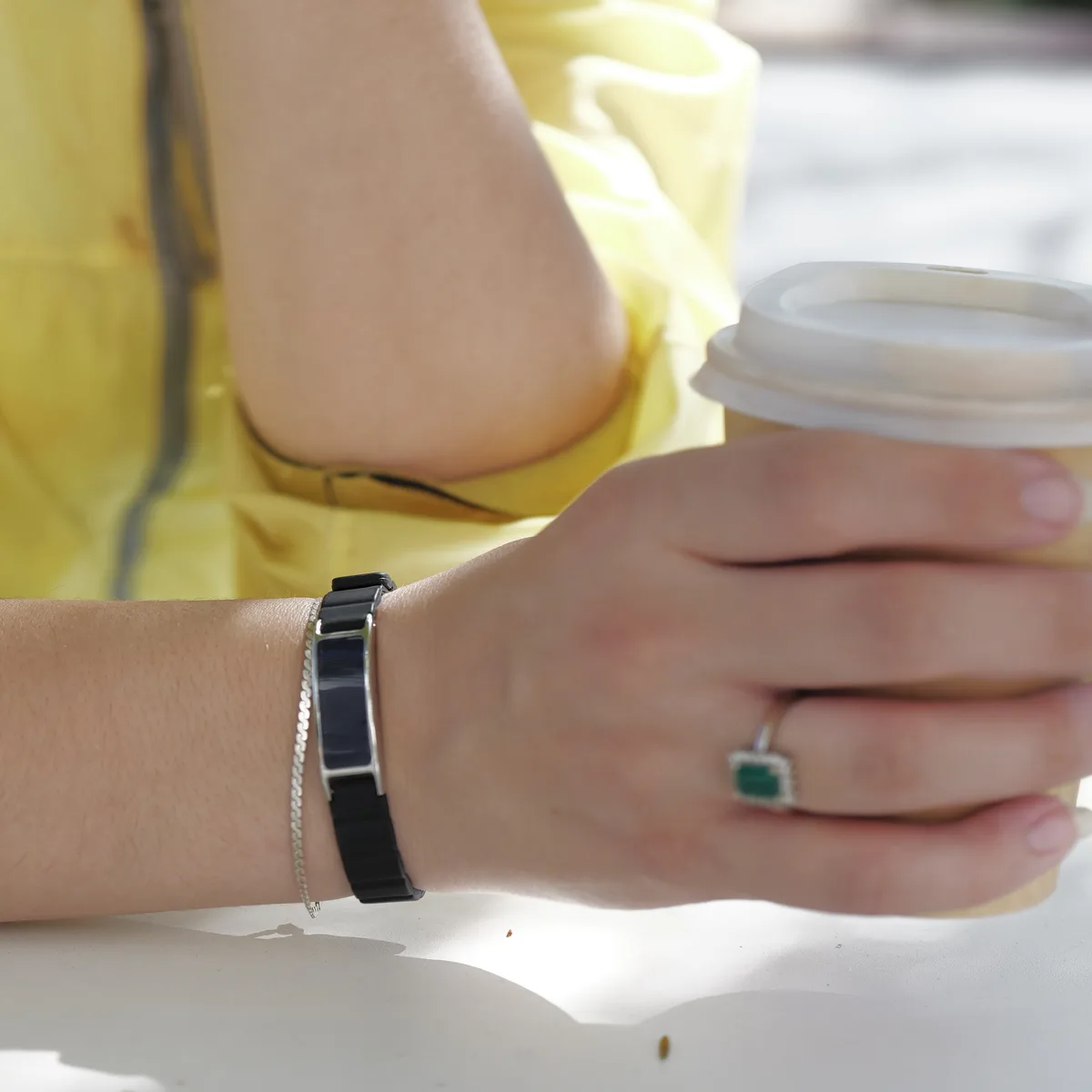 Silver Ray on a slim wrist holding a coffee cup