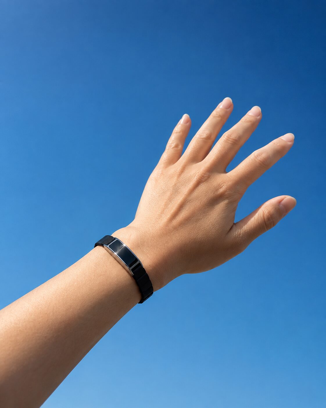 Ray worn on a wrist held up to a bright open sky