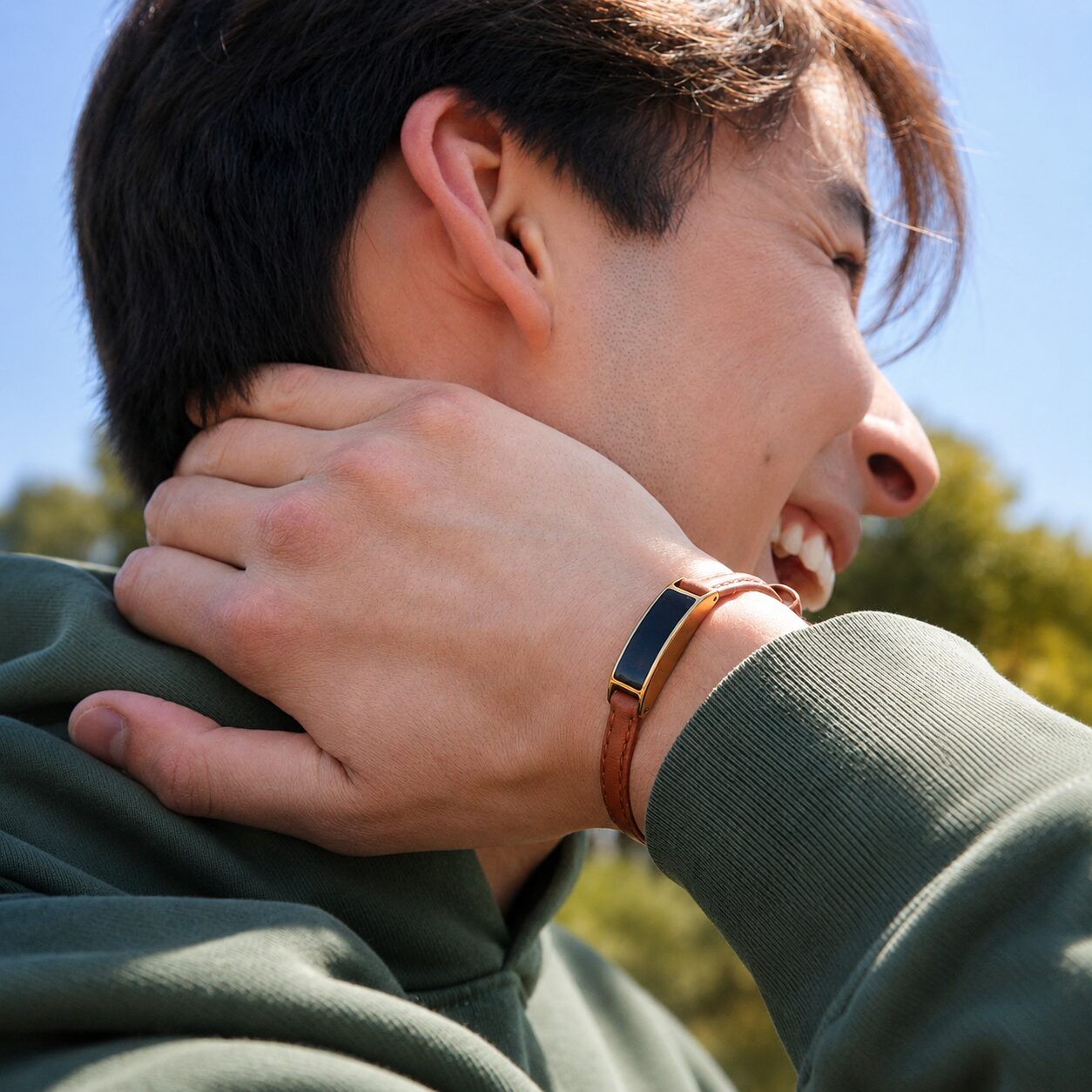 Smiling man wearing Ray with a hand on his neck