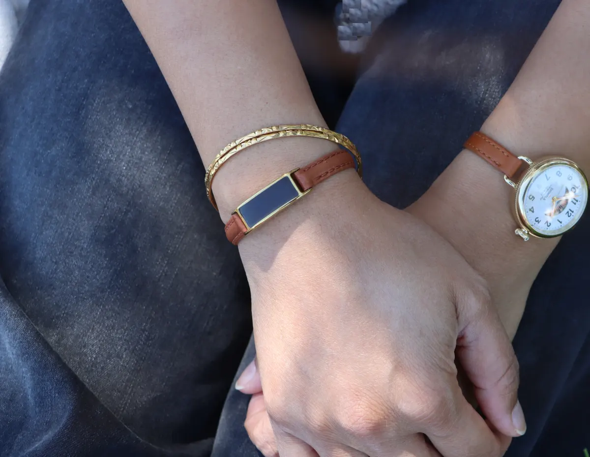 Ray health tracker on a wrist beside jewelry